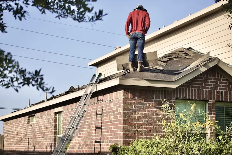Professional roofer working on a residential roof in Century South
